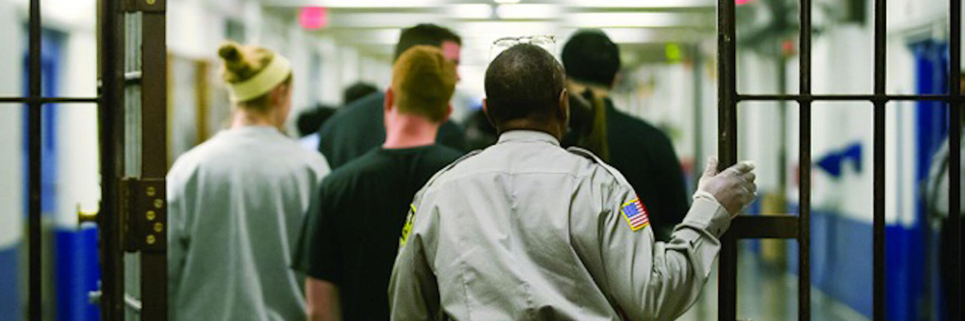 image of prison guards walking students through prison gates
