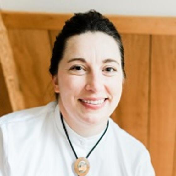 Ames Sutton Hickey in a white shirt smiling and staring into the camera
