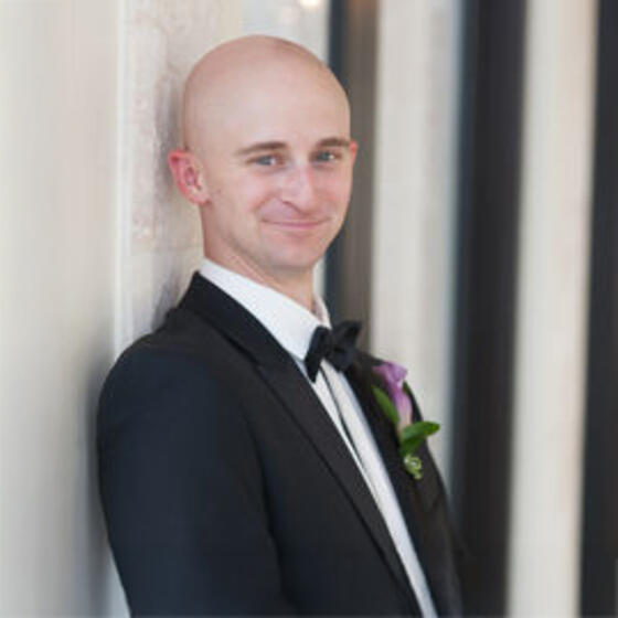 Joe Eanett in a black tuxedo smiling into the camera