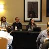 image of CJ faculty at a table at a conference looking at the presentation screen