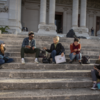 image of students and instructor sitting on the step in Ital reding a book