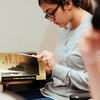 image of student studying a book at her desk
