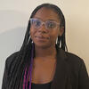 image of Jae'La wearing a black top and glasses smiling at the camera