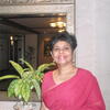 image of Srimati in a red sari standing in front of a mirror