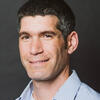Daniel Berman in a blue shirt smiling and staring into the camera