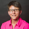 Elizabeth Groff wearing a pink shirt and staring into the camera
