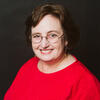 Robin Kolodny in a red shirt smiling and staring into the camera