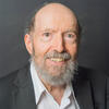 Aryeh Botwinick in a gray suit coat and white shirt smiling into the camera