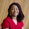 Casarae Abdul-Ghani in a red shirt smiling and staring into the camera