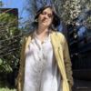 Chloe Sierka in a white shirt and yellow suit coat outside staring into the camera