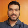 Anurag Jain in a black shirt in front of an orange wall staring into the camera