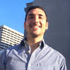 Damien Stankiewicz standing outside behind some building smiling and staring into the camera