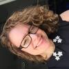 image of Karen wearing glasses and a black top smiling at the camera