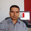Khila Dahal in an office in a gray shirt staring into the camera