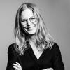 Kristin Gjesdal in a black shirt with her arms crossed smiling and staring into the camera