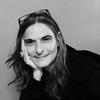 Patricia Melzer in a black shirt with her head leaning on her hand staring into the camera