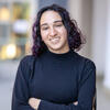 Rachel Bleiman outside in a black shirt with arms crossed smiling into the camera
