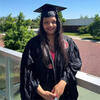 Shamim Pia outside in a graduation cap and gown staring into the camera