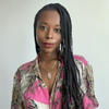 Tamar Sarai Davis in a pink, tan and black shirt staring into the camera