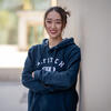 Yunming Jia in a blue sweatshirt with arms crossed smiling into the camera