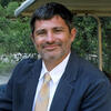 James Bachmeier in a suit and tie smiling and staring into the camera