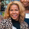 Camille V. Elliott wearing a leopard pattern jacket and black shirt smiling and staring into the camera