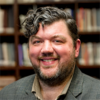 Rob Faunce smiling in front of a book shelf