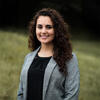 Sussan Saikali-Wehbe in a black shirt and gray suit coat smiling into the camera