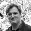 Paul Crowe standing outside smiling and staring into the camera