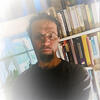 Terry Rey in front of a book shelf staring into the camera