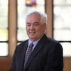 Peter Jones wearing a suit and tie staring into the camera