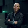 Espen Hammer in a black jacket with his arms crossed staring into the camera