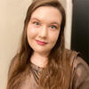 Veronica​​ Nelson in a brown shirt smiling into the camera